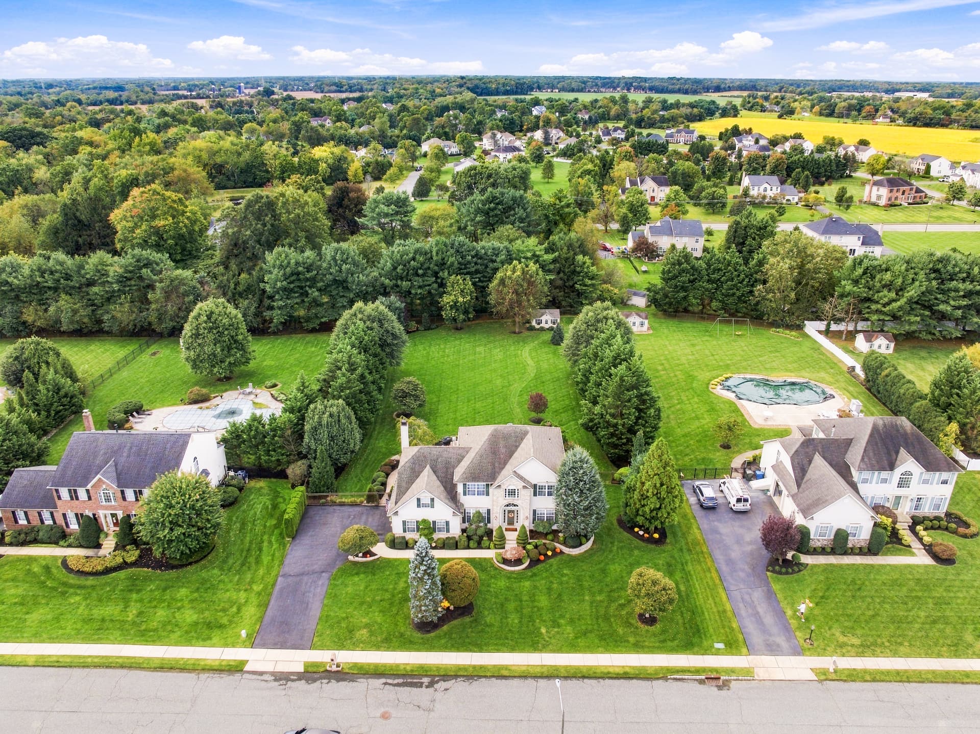 Aerial of a colonial on a deep lot with neighboring homes and farmland beyond, Lumberton, NJ