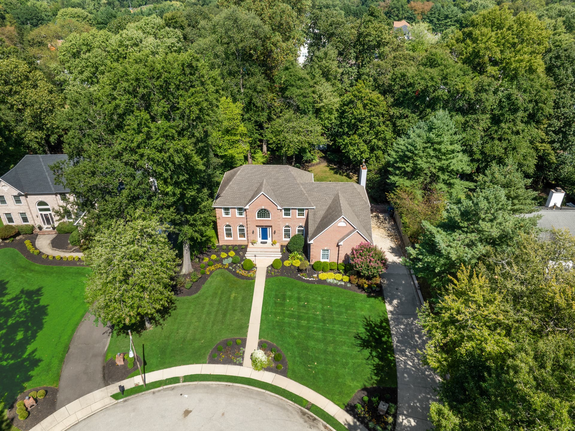 Drone photo of a brick colonial on a cul-de-sac with neighboring homes, Mount Laurel, NJ
