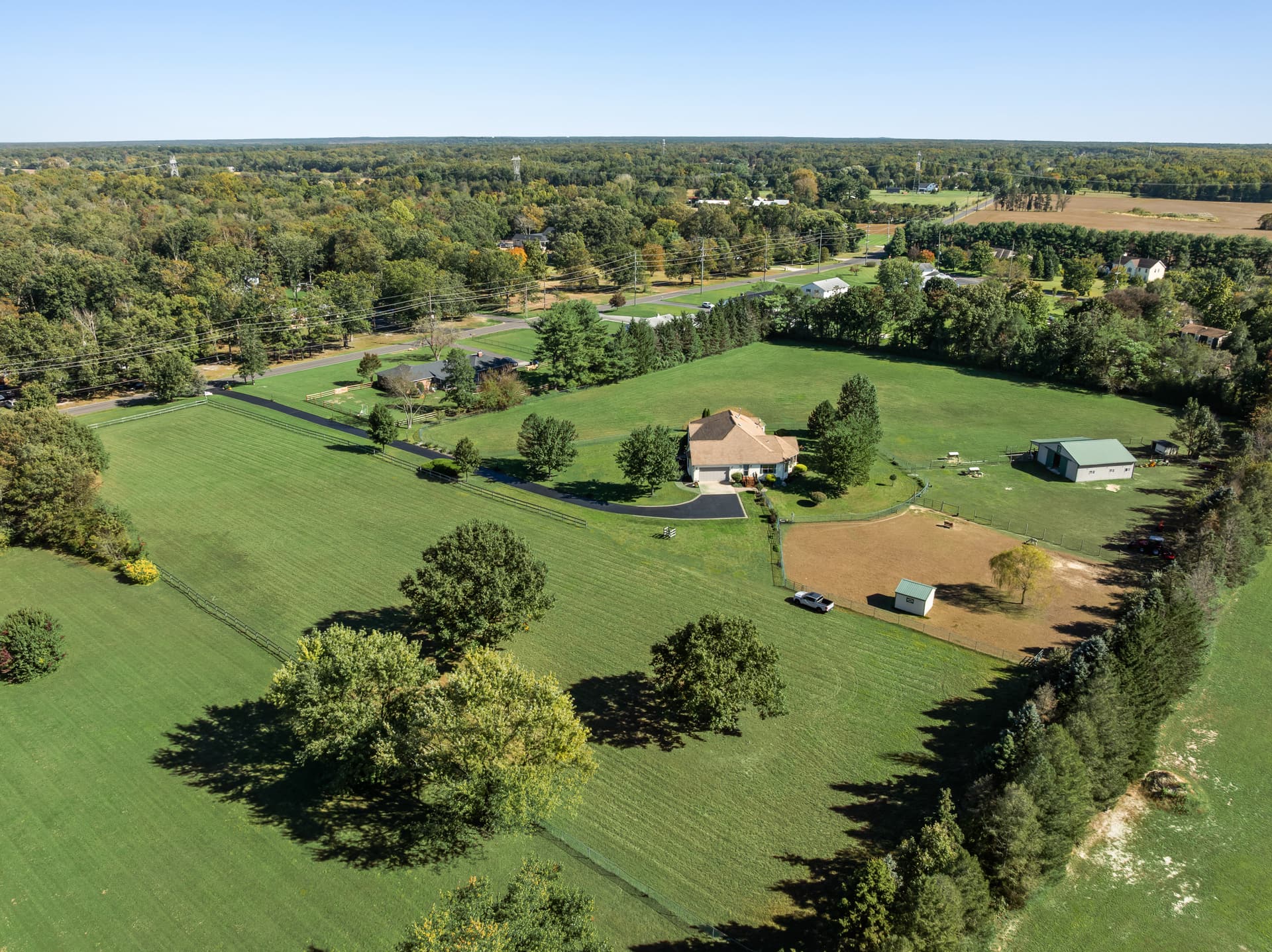 Aerial of a home on acreage with a barn, riding ring and fenced pasture, Southampton, NJ